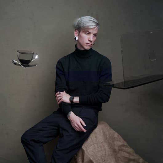 A portrait of the author, a young man with blonde hair, looking pensively at a ghostly floating glass laptop computer.